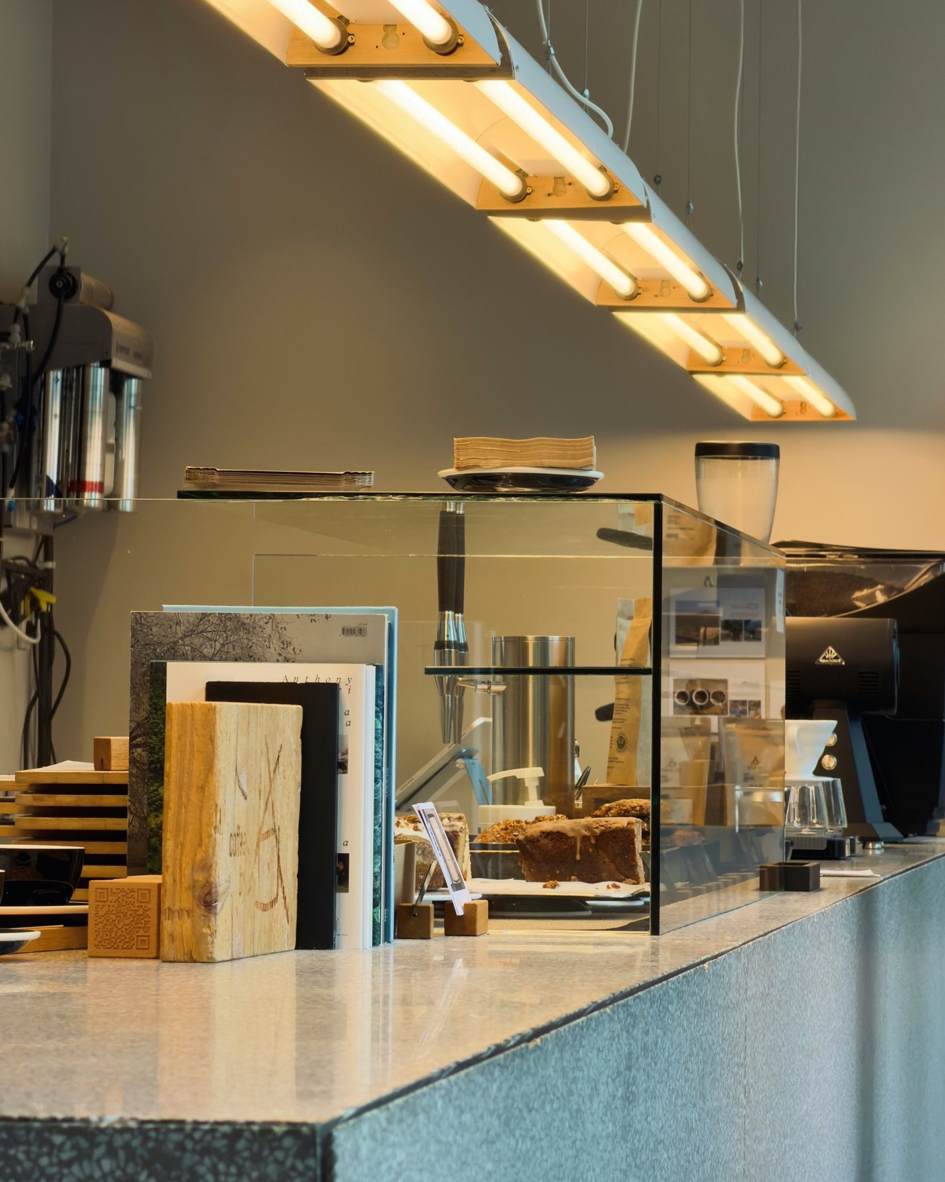 A small cafe counter with a display case in warm morning light.